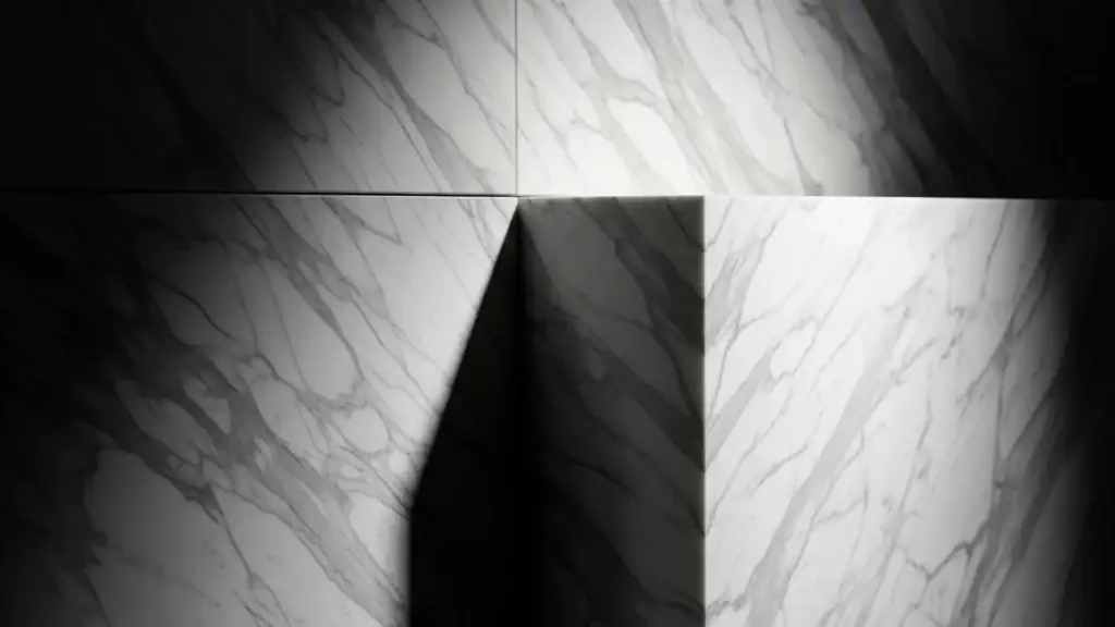 Superficie in marmo bianco con venature grigie e giochi di luce e ombra, eleganza essenziale e geometria naturale – architetto specchio Bolzano